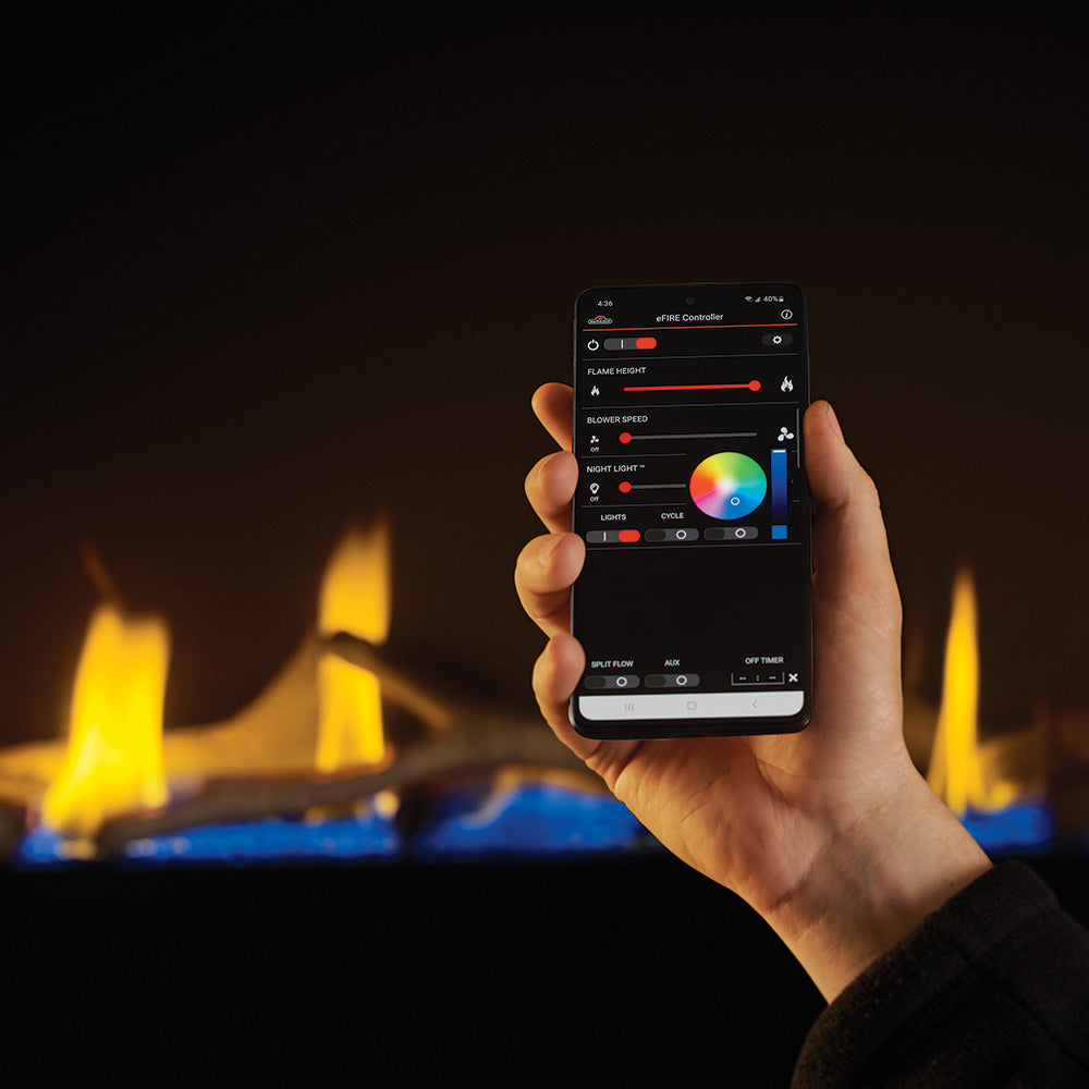 Hand holding mobile app remote with fireplace flames for linear direct vent gas unit