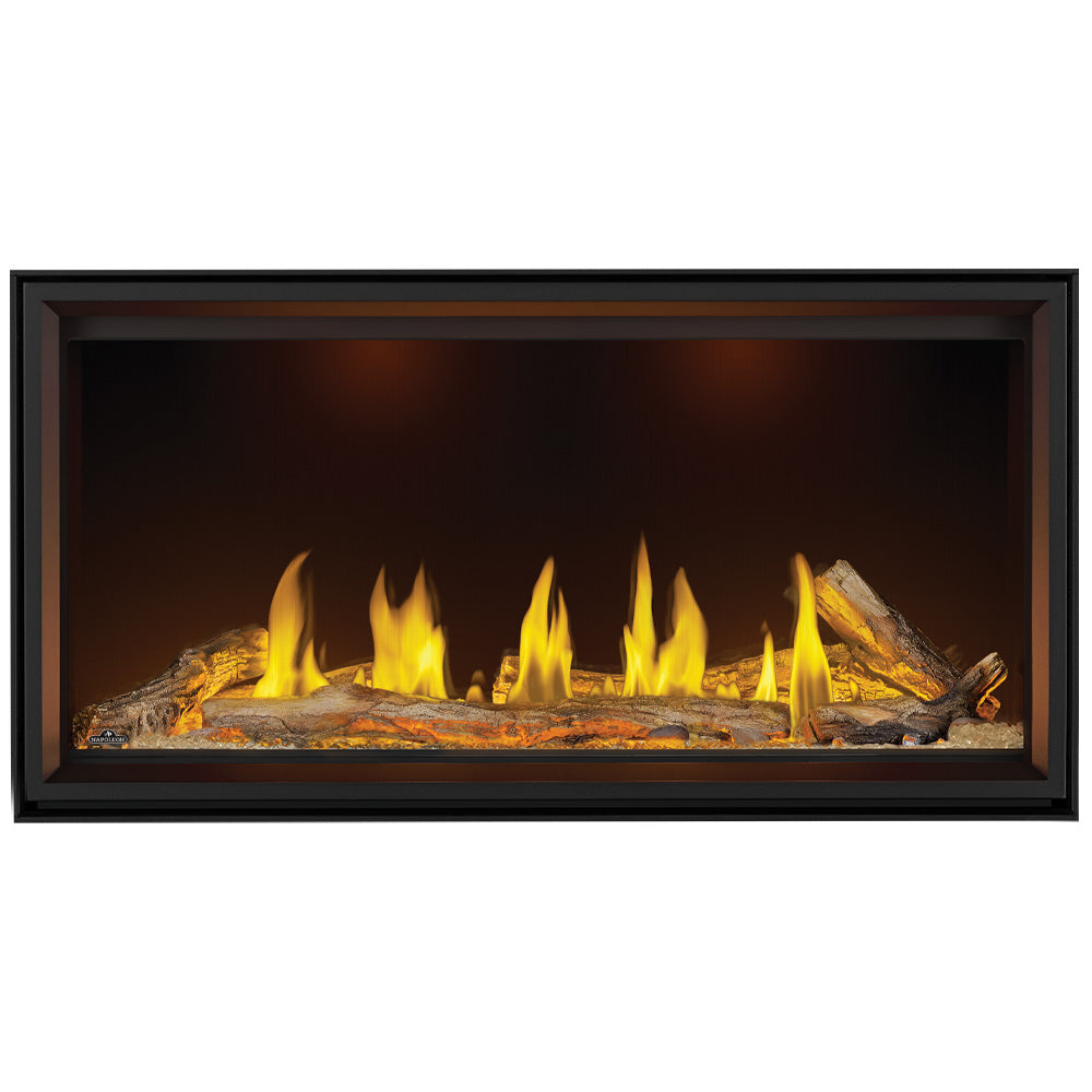 Black linear gas fireplace with bright flames across a log bed in the firebox