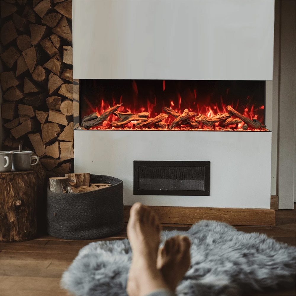 Built-in electric fireplace with visible flames and dark viewing panel in a white surround