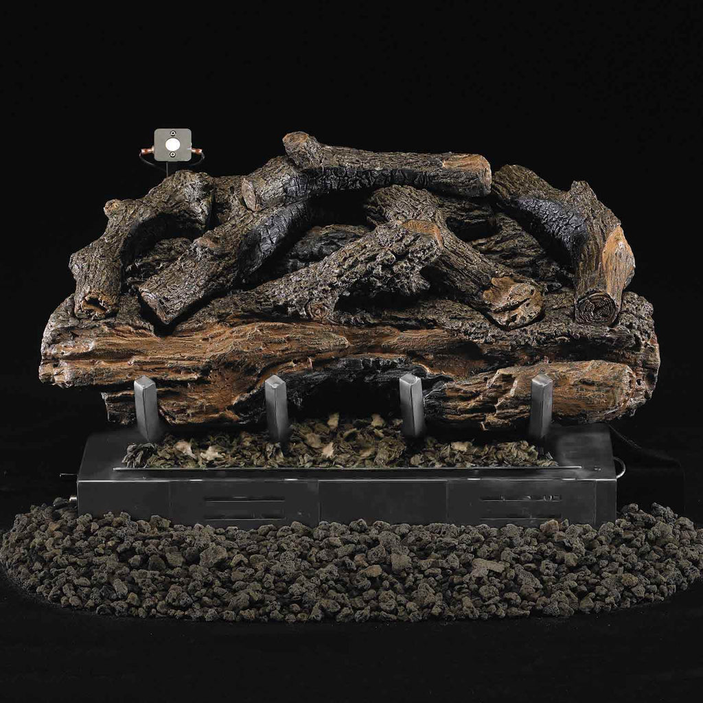 Charred aged ventless gas log set with lit flames over burner pan and black rocks