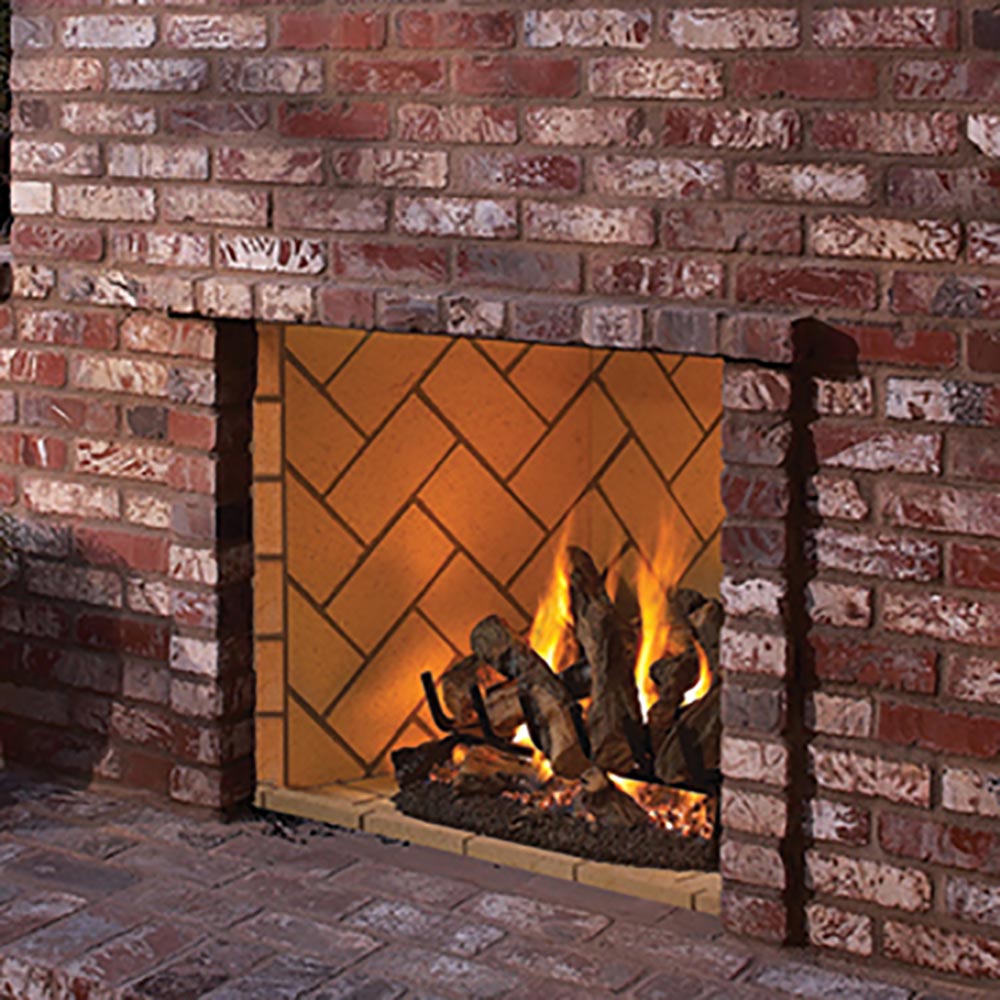 Masonry gas firebox with brick surround and lit logs visible through the front opening