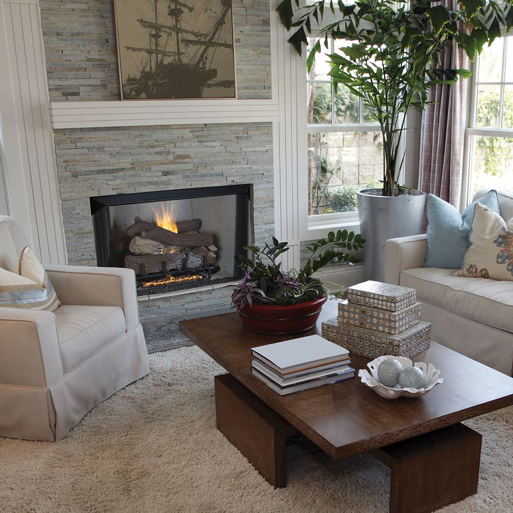 Black fireplace firebox with burning logs, set in a stone mantel surround