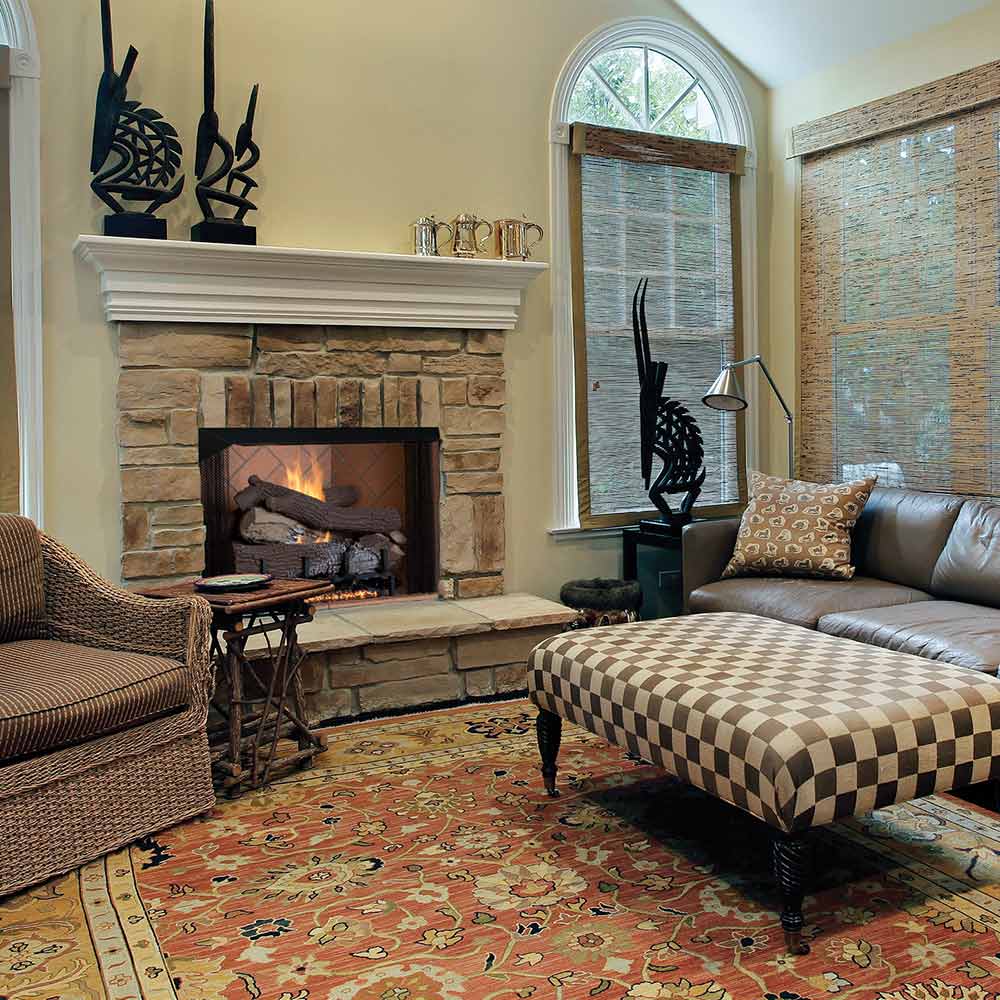 Mosaic masonry firebox with arched opening and stacked stone surround, dark firebox interior.