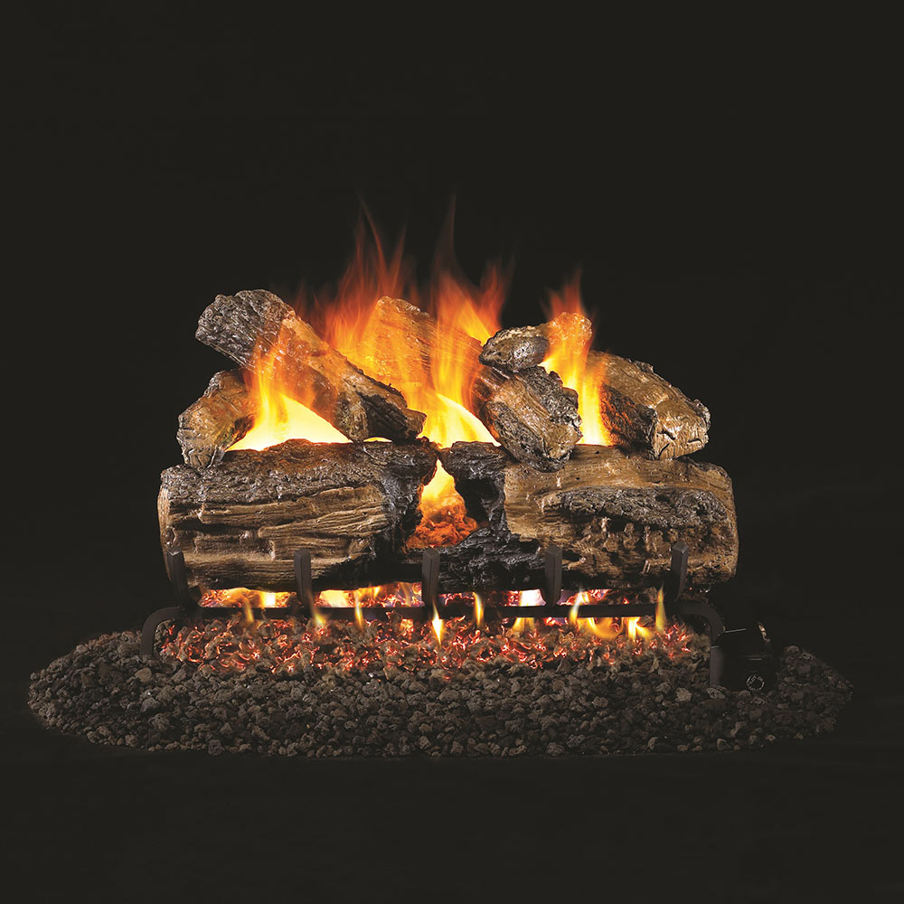 Burnt split oak gas logs with glowing flames on rock bed