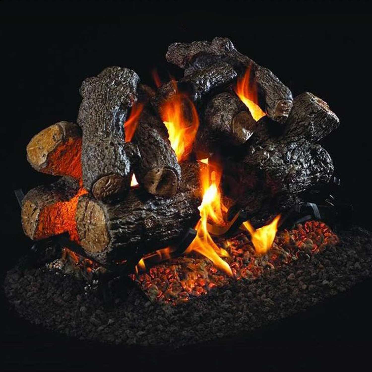Charred real-wood style gas log set with glowing flames in a dark firebed