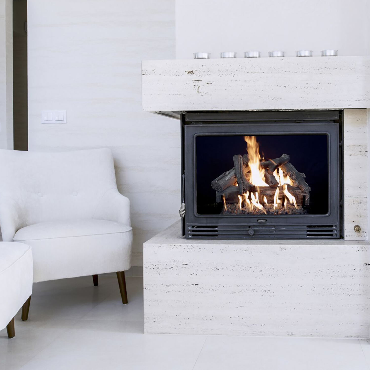 Vented gas log set in a fireplace with driftwood-style logs burning