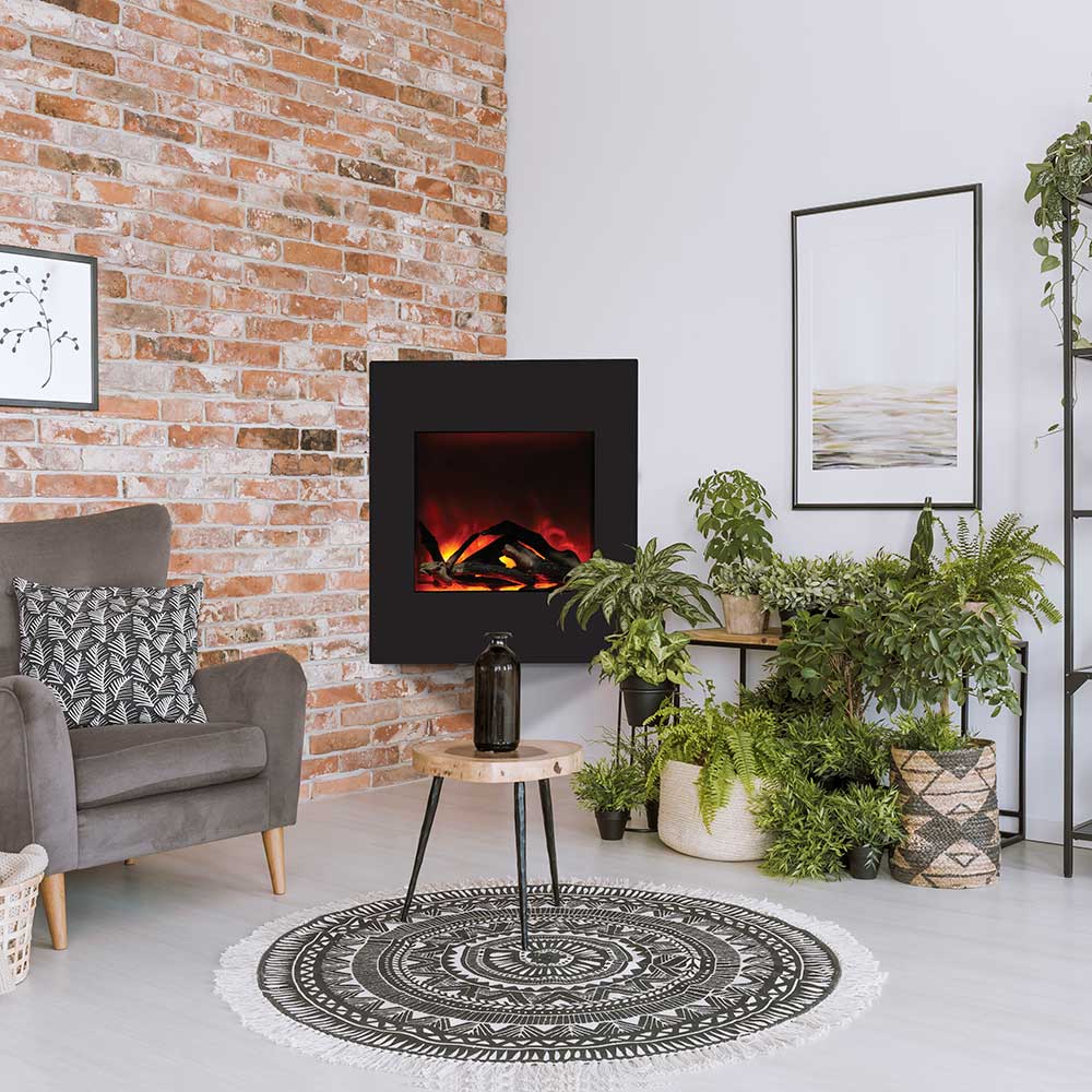 Black wall electric fireplace insert with glowing logs in a dark surround