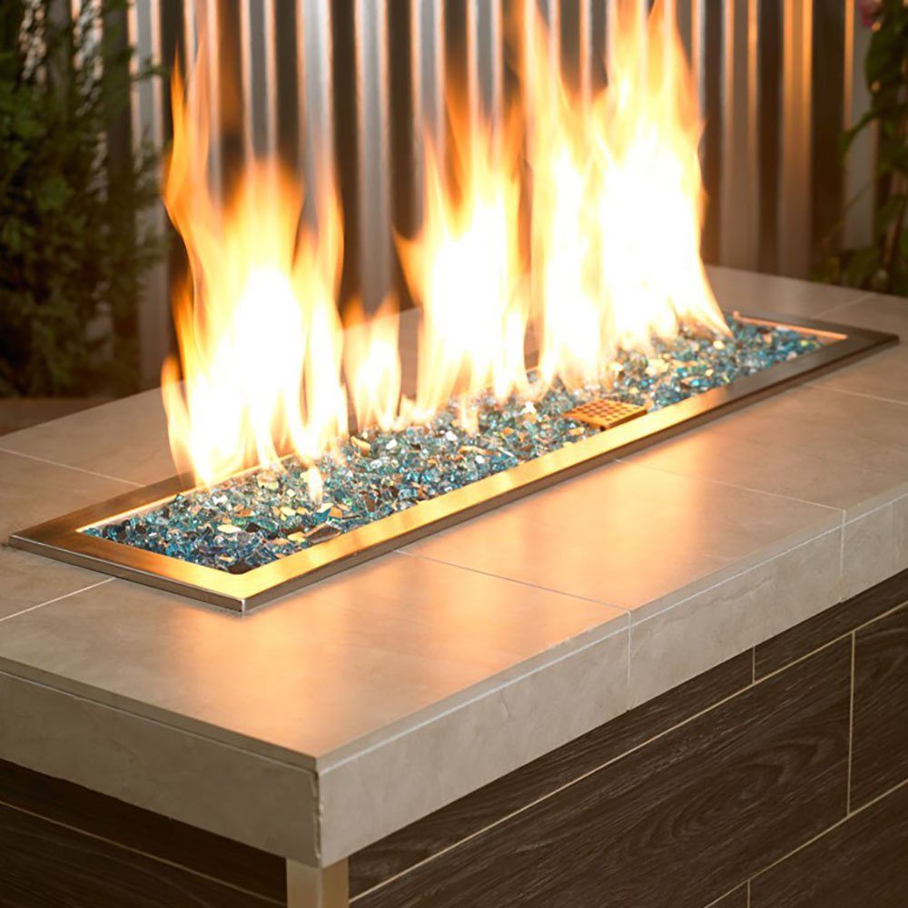Teal-blue reflective fire glass bed in an outdoor fire burner