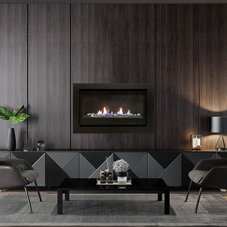 Black built-in gas fireplace with glass and pebble media, glass viewing window