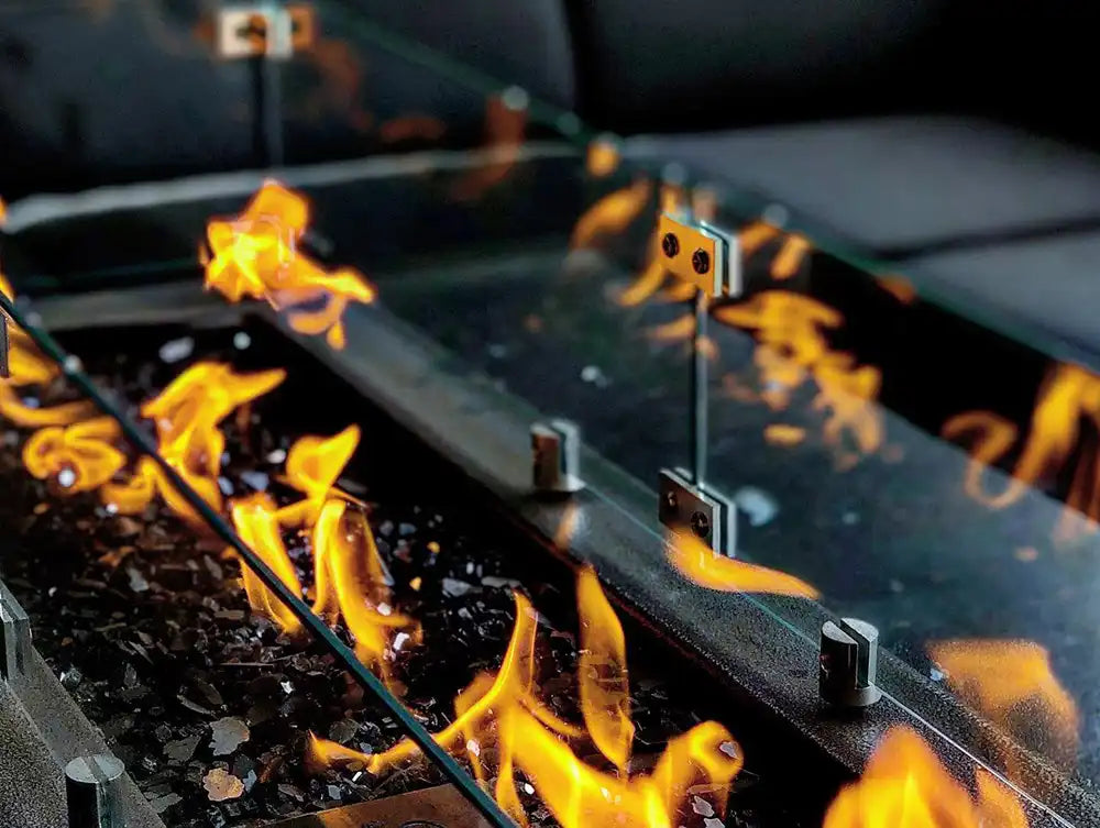 Close-up of a fire pit with flames and reflective surface