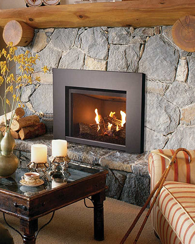 Gas fireplace insert set in stone wall with black surround and burning logs