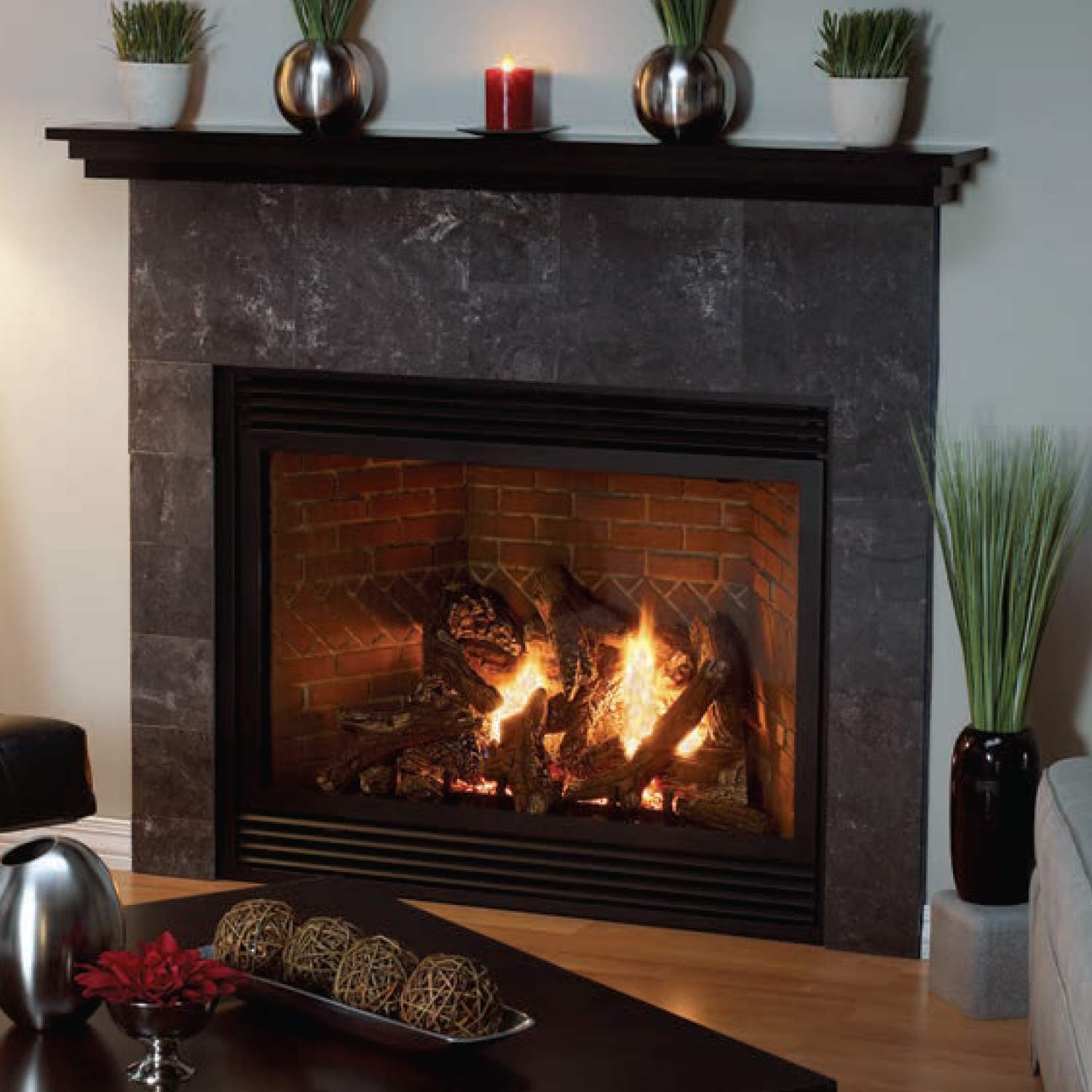 Direct vent fireplace with black surround and burning logs set in a brick firebox