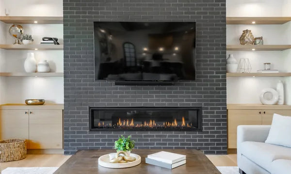 Elegant living room with a wide linear gas fireplace, built-in wood shelving, and warm ambient lighting