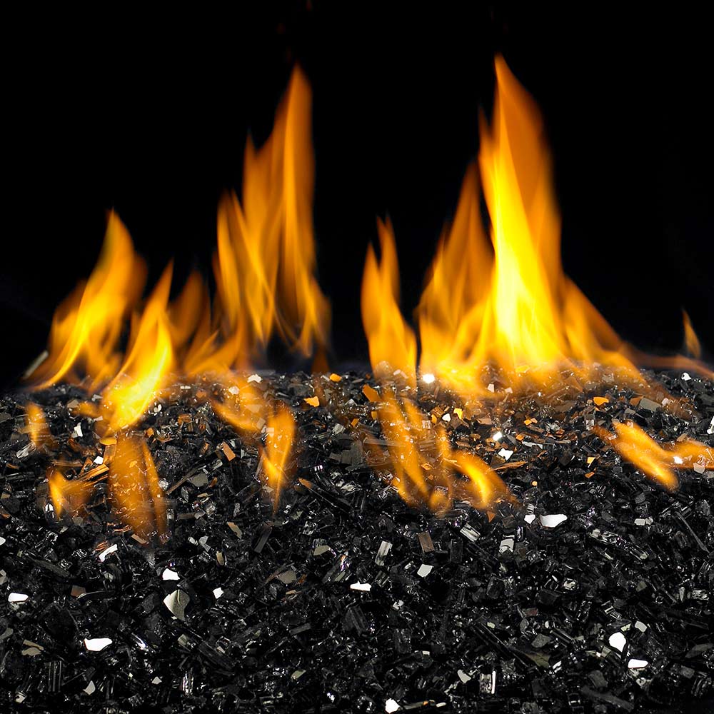 Reflective fire glass bed with bright orange flames burning above