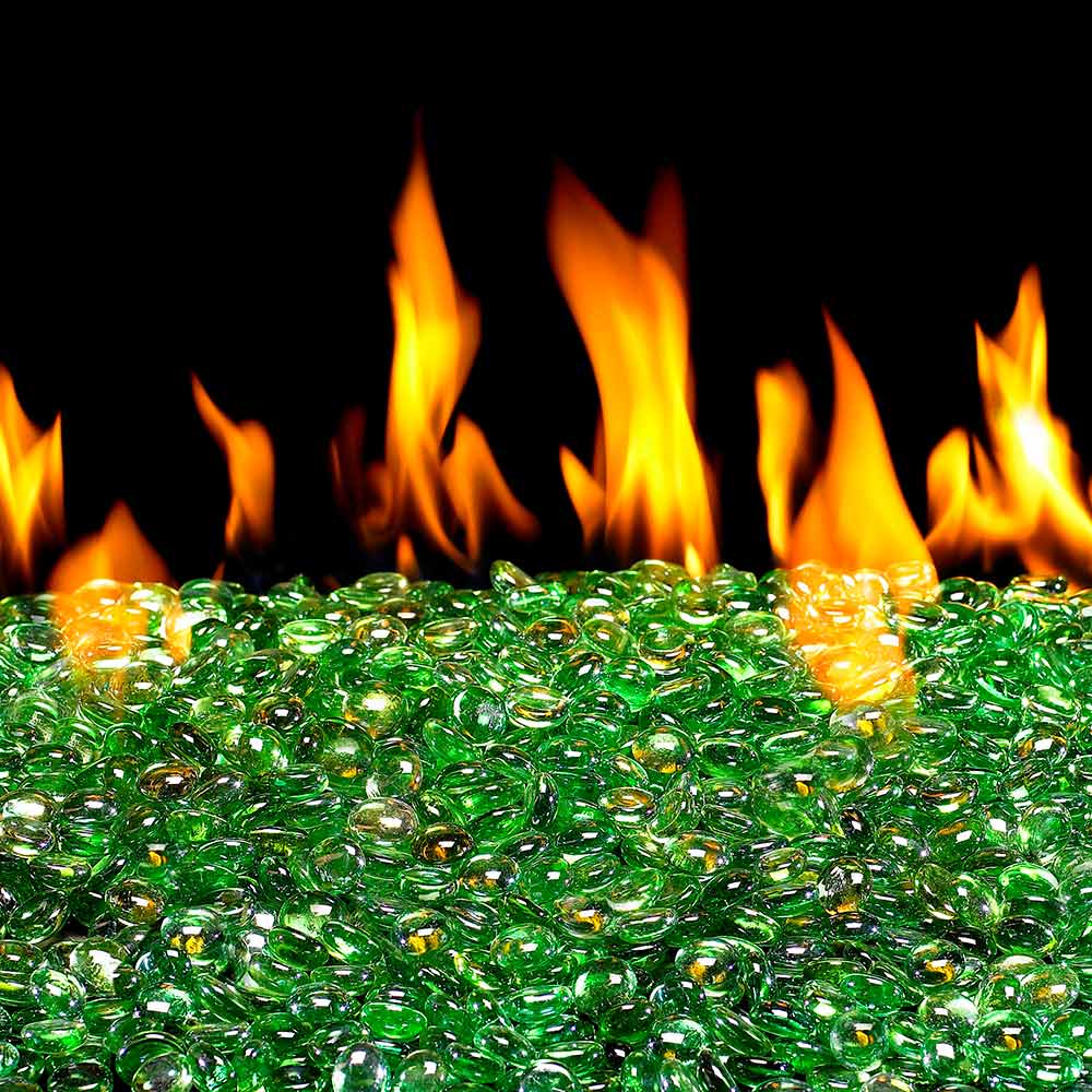 Green glass fire pit gems scattered in a bed, glossy faceted stones