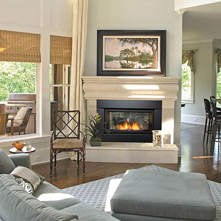 Built-in gas fireplace with black frame, fireglass and rock media, flames burning