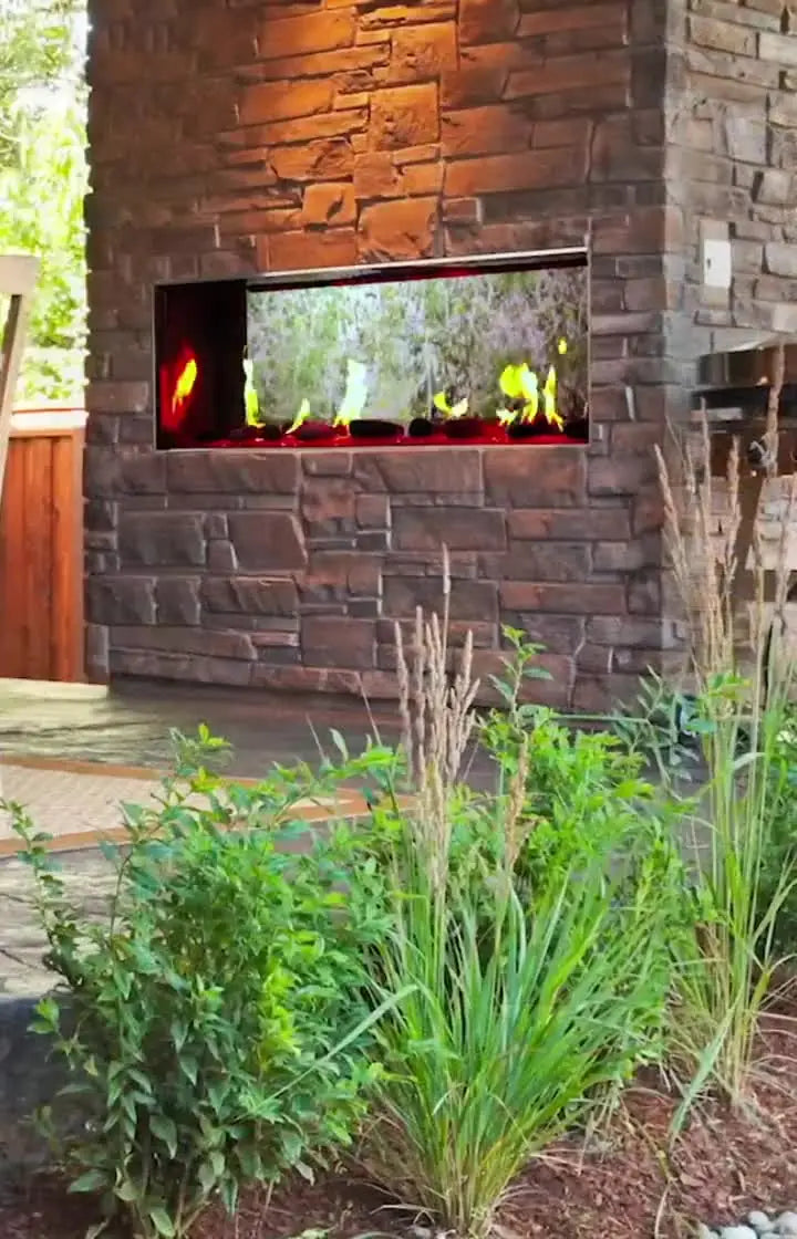 See-thru gas fireplace on an outdoor patio with a stone face surround