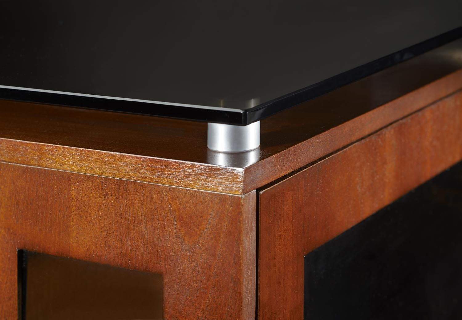 Brown wooden TV stand corner with metal trim and open cabinet opening